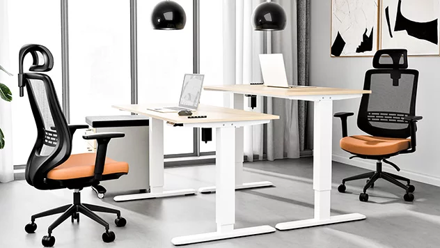 Marmurowa przestrzeń została wyposażona w szare, obrotowe krzesło tapicerowane - umieszczone przy dużym biurku z przystawką.